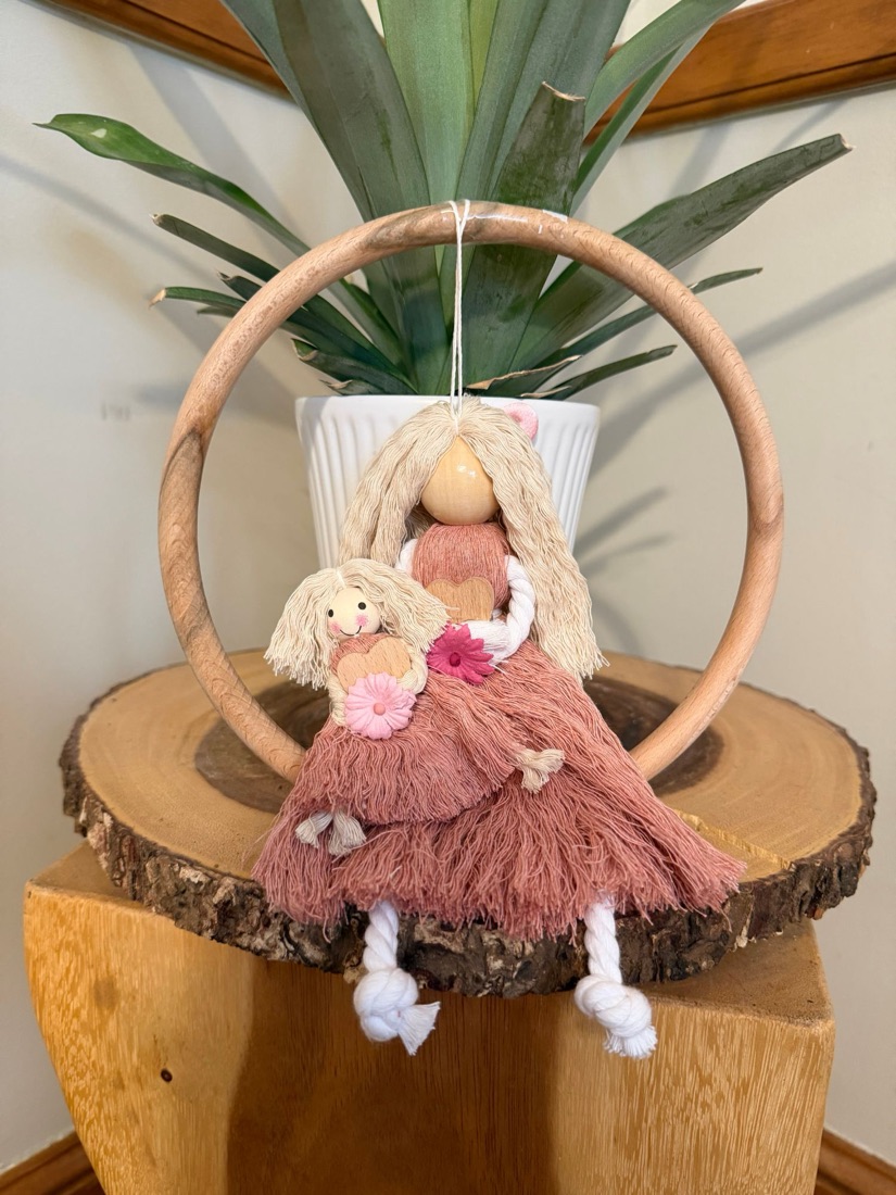 Macramé mother doll holding her little daughter in a wooden hoop